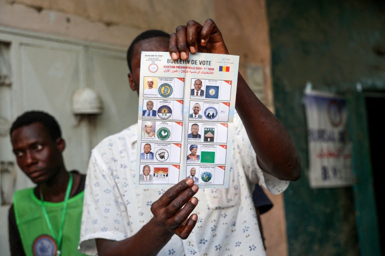 عامل اقتراع يحمل بطاقة اقتراع خلال السباق الرئاسي في تشاد.