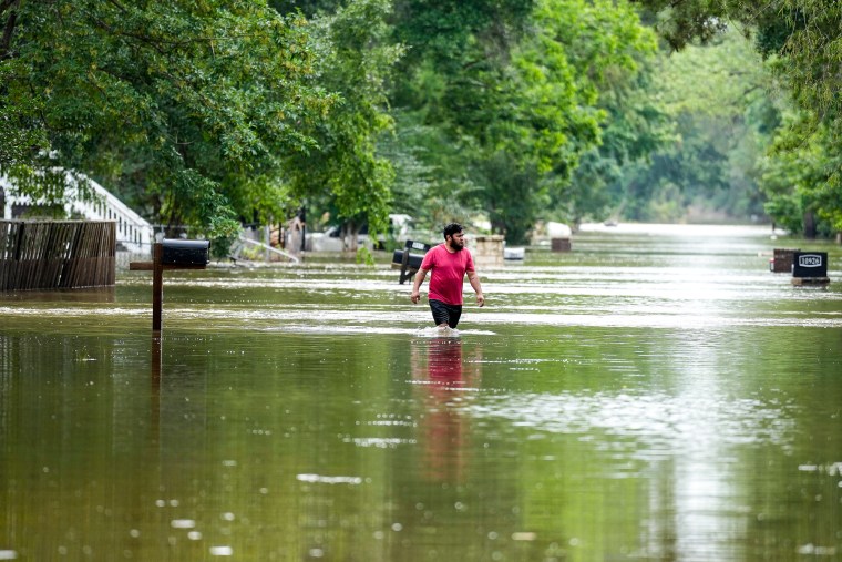 رجل يمشي وسط مياه الفيضانات